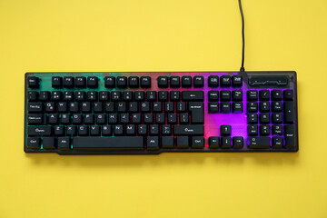 Modern RGB keyboard on yellow background, top view