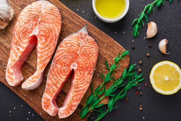 Top view raw salmon steaks on a cutting board with spices