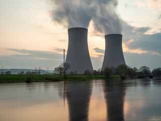 Nuclear power plant against sky by the river at sunset