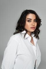 Portrait of woman in white shirt isolated on grey