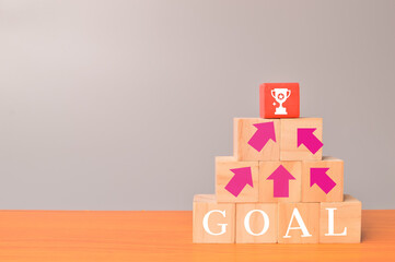 Target and goals concept. Phrase GOALS on wooden blocks with arrow and trophy icons
