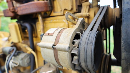 Old belt on alternator. Old black belt on pulley drive charger or engine alternator with copy space. Selective focus