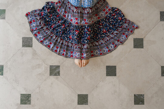 Woman With Blue Dress On Tile Floor Viewed From Above