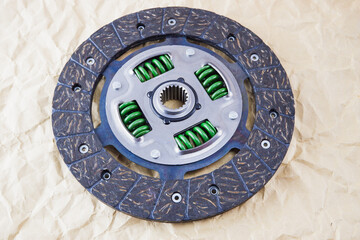 Car spare parts. Car clutch disc. Photo of a new clutch disc before installation on a car against a background of craft paper.