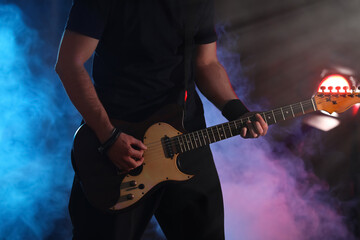 Obraz na płótnie Canvas Man playing electric guitar on stage, closeup. Rock music