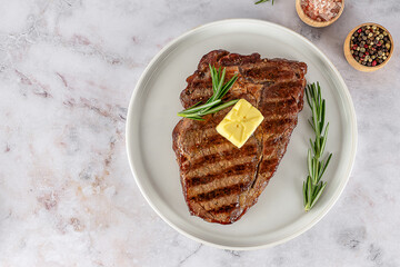 The rib eye or ribeye medium steak, marbled beef meat cooked on the grill with butter and seasonings