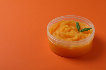 Cosmetic skin care scrub on orange background