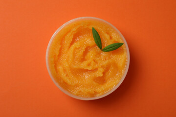 Cosmetic skin care scrub on orange background