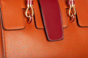 Part of a orange leather ladies bag with a closed pocket flap and good texture.