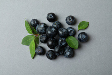 Fresh blueberry with leaves on gray background