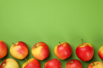 Ripe apples on green background, space for text