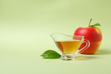 Homemade apple vinegar and ingredient on green background
