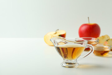 Homemade apple vinegar and ingredients on white table