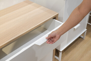 man open shelf, pull open drawer wooden in cabinet.	