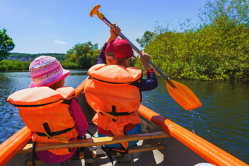 a family on a canoe excursion in summer - active vacation