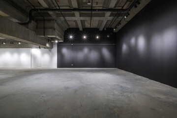 empty interior of large concrete room as warehouse or hangar with spotlights