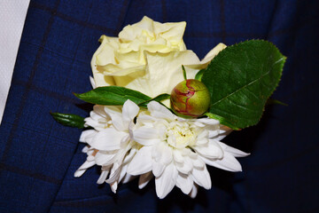 Wedding flower boutonniere on the groom's jacket