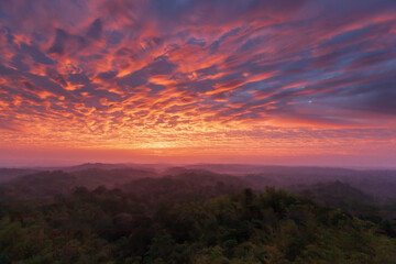 Dramatic clouds on the sunrise sky over mountains.