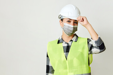Waist up portrait of female builder with hardhat on white background