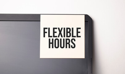 Sticky note on the computer. Text FLEXIBLE HOURS
