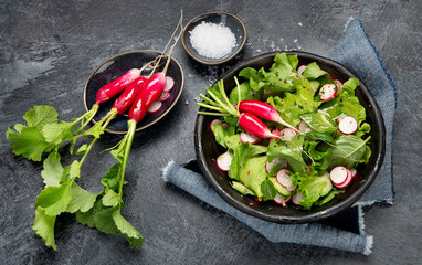 Fresh radish salad on drak gray background. Healthy food concept.