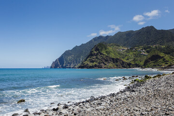 overview of Porto da Cruz basaltic beach with Larano mountains as background in Madeira island