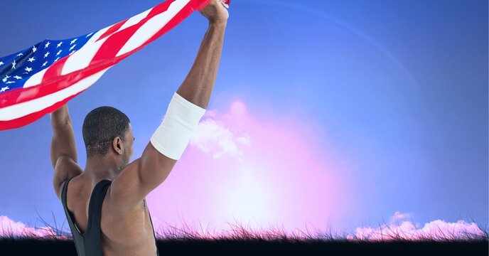 Composition of male athlete holding american flag against sky