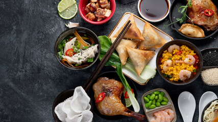 Assorted Chinese dishes and snacks on dark gray background. Traditional food concept.