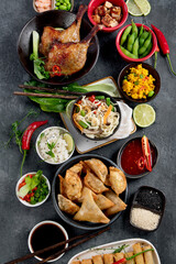 Assorted Chinese dishes and snacks on dark gray background. Traditional food concept.
