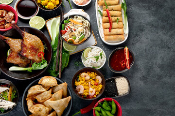 Assorted Chinese dishes and snacks on dark gray background. Traditional food concept.