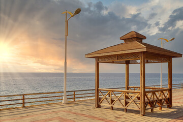 Sunset on a sea shore. Sea relax vacation holiday concept. Shore recreation zone with shelter spot and a view at the sea.