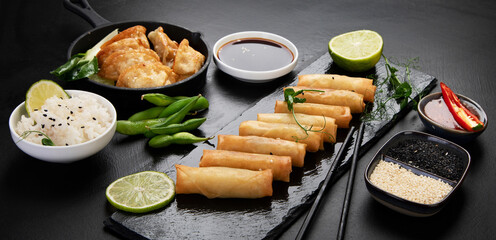 Assorted asian dishes and snacks on black background. Traditional food concept.