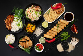 Assorted asian dishes and snacks on black background. Traditional food concept.