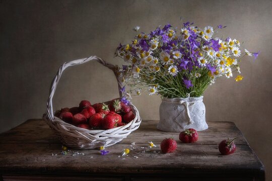 Still life with bouquet of wildflowers and strawberry
