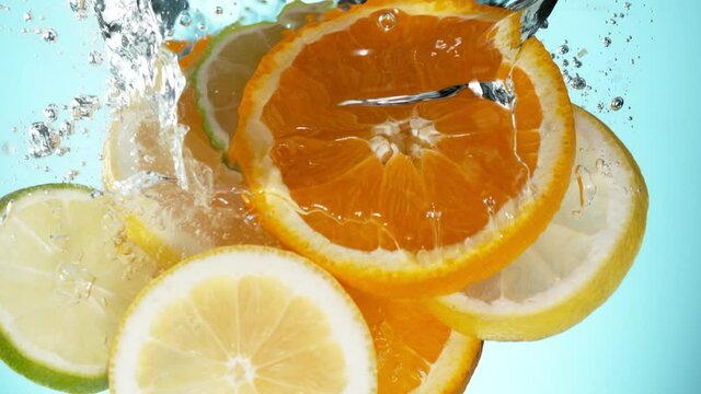 Super slow motion of falling lime, orange and lemon slices into water. Filmed on high speed cinema camera, 1000 fps.