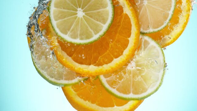 Super slow motion of falling lime, orange and lemon slices into water. Filmed on high speed cinema camera, 1000 fps.