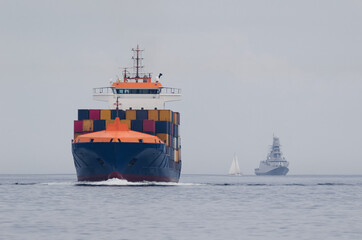 CONTAINER SHIP AND WARSHIP - Freighter and frigate sails on the sea