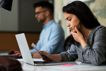 Beautiful young businesswoman working on laptop. Portrait of beautiful businesswoman in the office