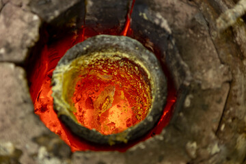Closeup of glory hole with orange and red tones of super heated mix of metals tin and copper in...