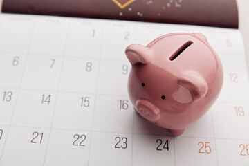 A piggy bank on a white calendar background, time to start saving