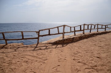 Fototapeta na wymiar Wooden fence on beach and red sea
