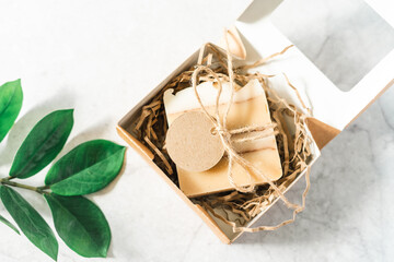 Soap in Craft Gift box or present box with bow on white background with mockup label tag. Copy space for text and design. Package, zero waste, plastic free, eco friendly natural organic concept.