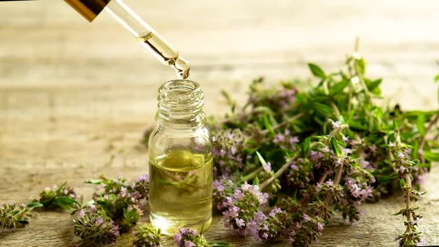 Thyme essential oil in a small bottle. Selective focus.