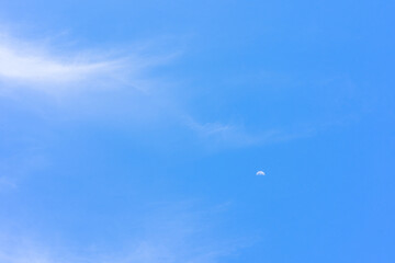 Fototapeta na wymiar Blue sky with tiny cloud and moon background.Blue sky with tiny cloud and moon background.