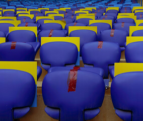 Seats in a football stadium during a pandemic through one taped to keep distance