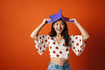 Happy young brunette asian woman holding copybook