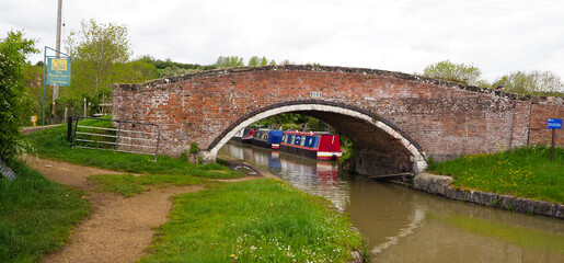 attractive brick bridge and moored narrowboats at napton on the Hill