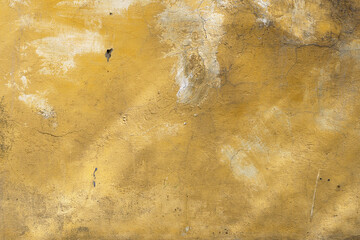 Background with an old concrete wall with an orange cracked paint lit by sun rays