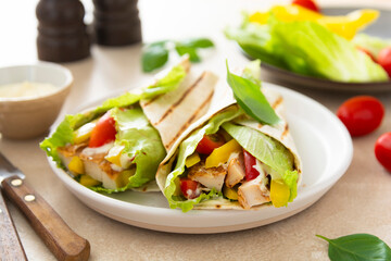 Wrap burrito sandwich or kebab with flatbread with vegetables and white meat.