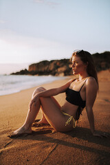 Fototapeta na wymiar Chica guapa en la playa del sur de españa en verano disfrutando de sus vacaciones en traje de baño bikini